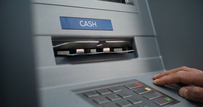 Close Up Shot of Person Pressing Buttons on ATM Keypad, Entering PIN Code. ATM Dispensing Money, User Taking Cash Dollars from Cash Machine. Banking Services, Withdrawal Operations and Transactions.