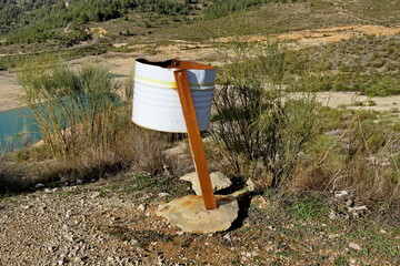 Poubelle en fer rouillé dans un parc. Vieux bidon métallique de récupération.