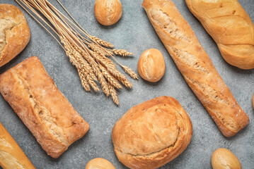 Various fresh bread on grey rustic background, top view