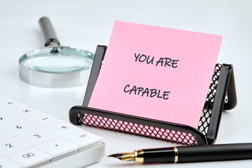 Business capable or incapable concept. Copy space. Motivational words YOU ARE CAPABLE on a sticker...