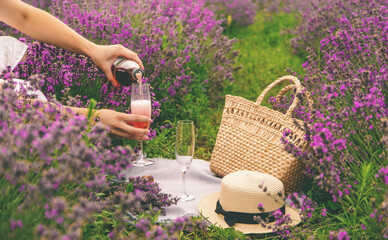 Woman in a white dress in a lavender field with champagne. Vacation