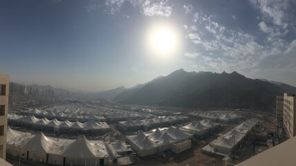 Panoramic View of Tented Camps and Mountains Under Bright Sunlight