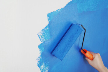Roller Brush Painting, Worker painting on surface wall Painting apartment, renovating with blue...