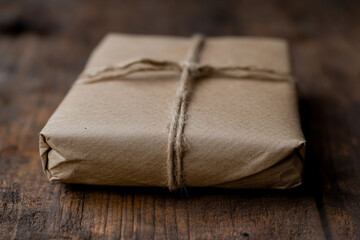 Surprise gift wrapped in brown paper creates an atmosphere of joy and excitement during a festive gathering