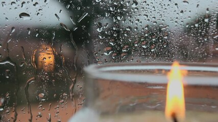 Rainy day window reflection candlelight warm glow comfort peace serenity home solace rain droplets windowpane blurred view cozy atmosphere quiet evening. 4k Vidios