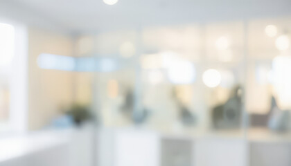 Blurred interior view with glass walls and white surfaces creating a bright space.