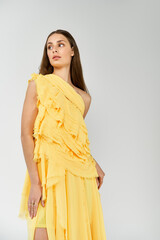 Beautiful young woman showcasing summer fashion in a vibrant yellow dress with stylish texture