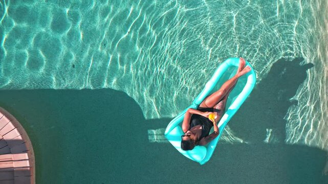 Woman relaxing on float in a tranquil pool setting
