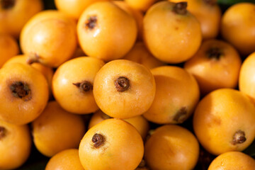 Ripe loquats fruit on wooden table.