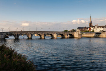 Obraz premium Maastricht, Netherlands - September 17, 2024: View of the old stone bridge on the city's waterfront