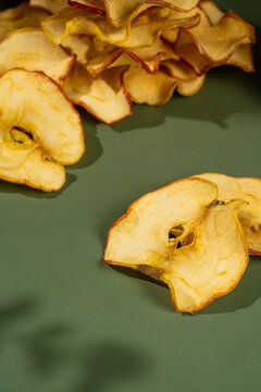 Slices of dried apples on a green background