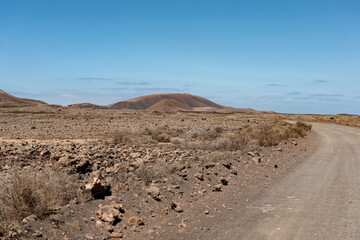 Expansive desert landscape in Fuerteventura with rocky terrain and blue skies