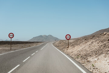 Desert road in Fuerteventura featuring traffic signs