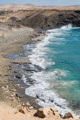 Waves gently crashing against the rocky shoreline of Fuerteventura coastline