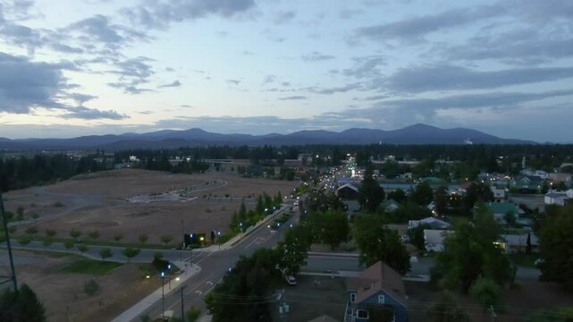 Aerial Downward Scenic View Of Houses Amidst Trees In Town By Mountains At Dusk - Post Falls, Idaho