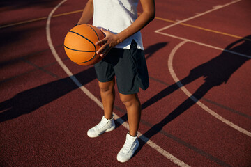 Naklejka premium Closeup view on basketball ball in hand of young girl player