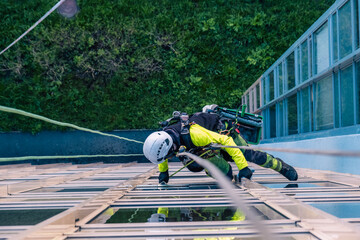 Rope access specialist washes the facade of a building