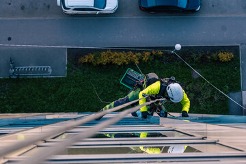 Rope access specialist washes the facade of a building