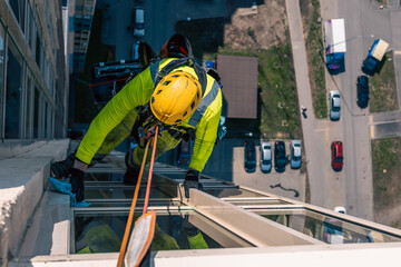 Rope access specialist washes the facade of a building