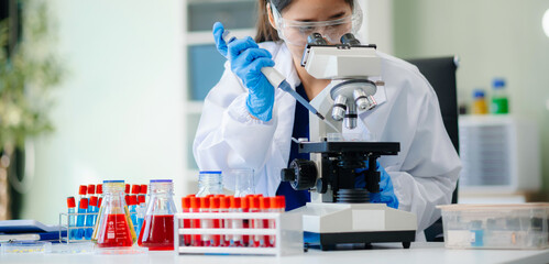 Discover a dedicated scientist conducting laboratory research, using pipettes, microscopes, and lab...
