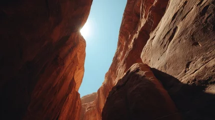 Gardinen Canyon walls rise to meet the sky in a dramatic low angle shot  sandstone cliffs in a desert landscape under a bright sun © Tam5