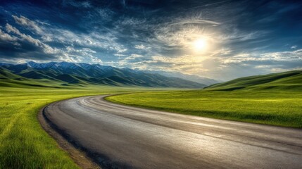 Fototapeta premium Scenic Road Through Green Hills Leading to Snow-Capped Mountains at Sunrise Landscape Perspective in Kyrgyzstan