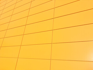 Modern yellow building facade with rectangular panels creating geometric pattern