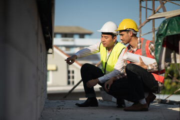 Civil engineer with personal safety equipment checking and consult with construction site foreman...