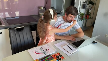 Adorable young girl with headphones on, interacting with her father who is working from home on his laptop, while she is drawing with colored pencils - Powered by Adobe