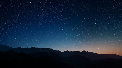 a a movement of stars in the night sky with the view of mountains.