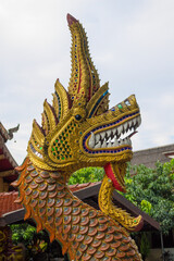 Fototapeta premium Description Colorful dragon statues in interior and exterior of buddhist temple Wat in Thailand. Thai traditional religious Buddhist architecture with statues of Asian dragons decoration. Thailand tra