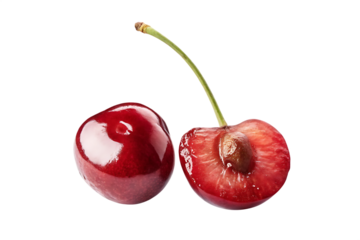 Juicy red cherries one whole and one halved with visible seed isolated on black