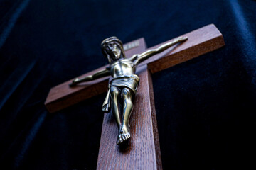 Crucifix of Jesus Christ in Gold on Wooden Cross with Dark Background
