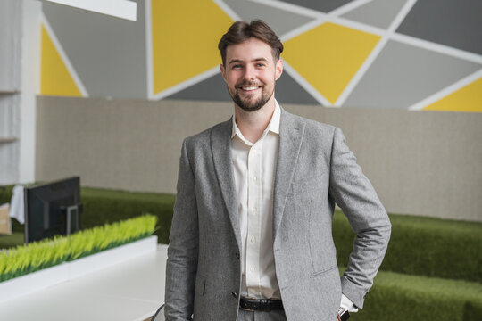 Happy professional business man in formal wear suit company employee, young entrepreneur, smiling Caucasian businessman working in modern light office looking at camera portrait.