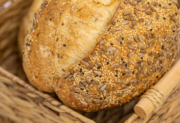 Close-up of a delicious artisan bread loaf with seeds on a white surface