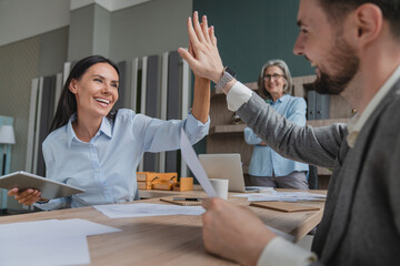 Businesswoman giving hi five touching hands with co worker after finish work and completed the work perfectly, as expected. Happy team giving hight five after successful work