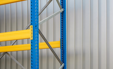 A close-up view of a sturdy industrial pallet racking system featuring against a light gray corrugated metal wall. Suitable for logistics, manufacturing,or industrial supply projects.