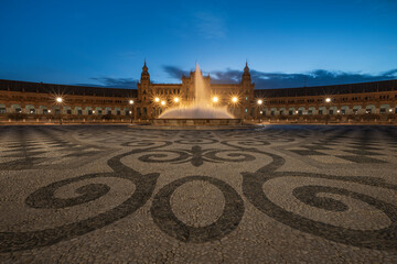 The Plaza de Espana, in Seville, Andalusia, Spain, at sunrise. Focus on the water fountain in the middle of the plaza and the intricate patterned floor. Long exposure 