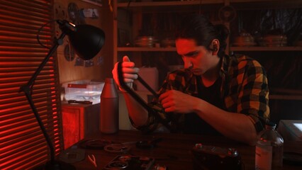 Person Examining Film Strip in Darkroom with Red Light