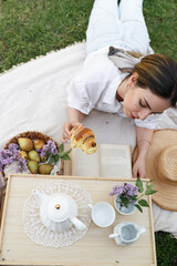 Woman Reads Book During Springtime Picnic Outdoors