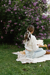 Woman Reads Book During Springtime Picnic Outdoors