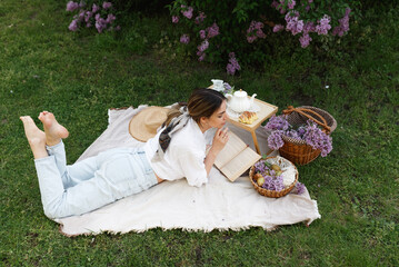 Woman Reads Book During Springtime Picnic Outdoors