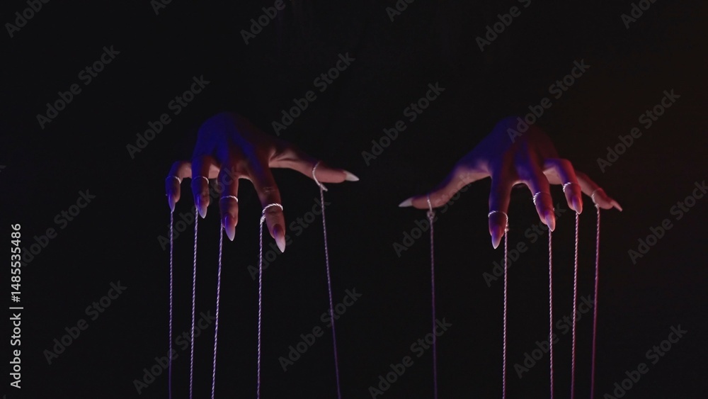 Poster hands manipulating puppet strings in dramatic lighting