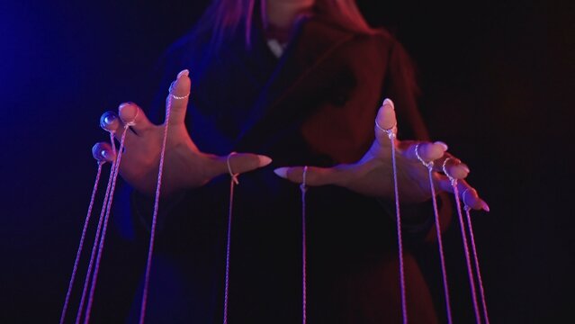 Fototapeta Mysterious Hands Manipulating Strings in Dark Room