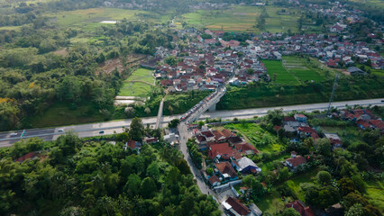 Aerial View of Rural Village and Busy Bridge Over Toll Road