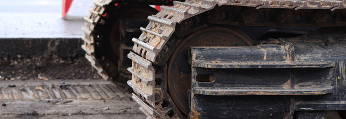 Close-up of excavator track. Close-up of part of construction excavator, tracked vehicle. Repair work in the city. Special equipment. Equipment at the construction site. Heavy construction equipment © Mariia