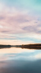 Fototapeta premium Serene Sunset Over Calm Lake with Reflective Water and Soft Colorful Sky