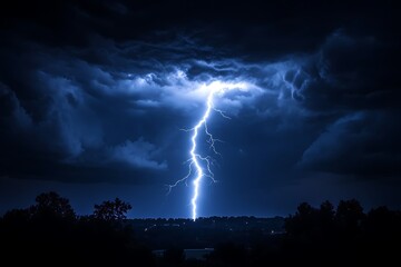 Majestic lightning bolt illuminating a stormy night sky above silhouetted trees and landscape