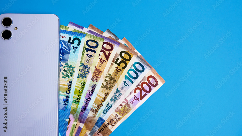 Poster smart mobile phone with back facing camera and ghanaian cedi ghana cedis notes on blue background wi