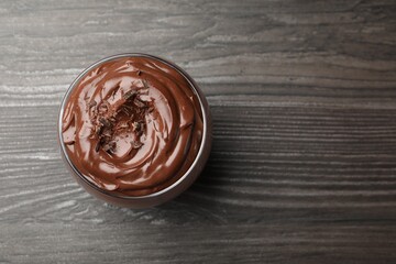 Delicious chocolate pudding in glass on wooden table, top view. Space for text